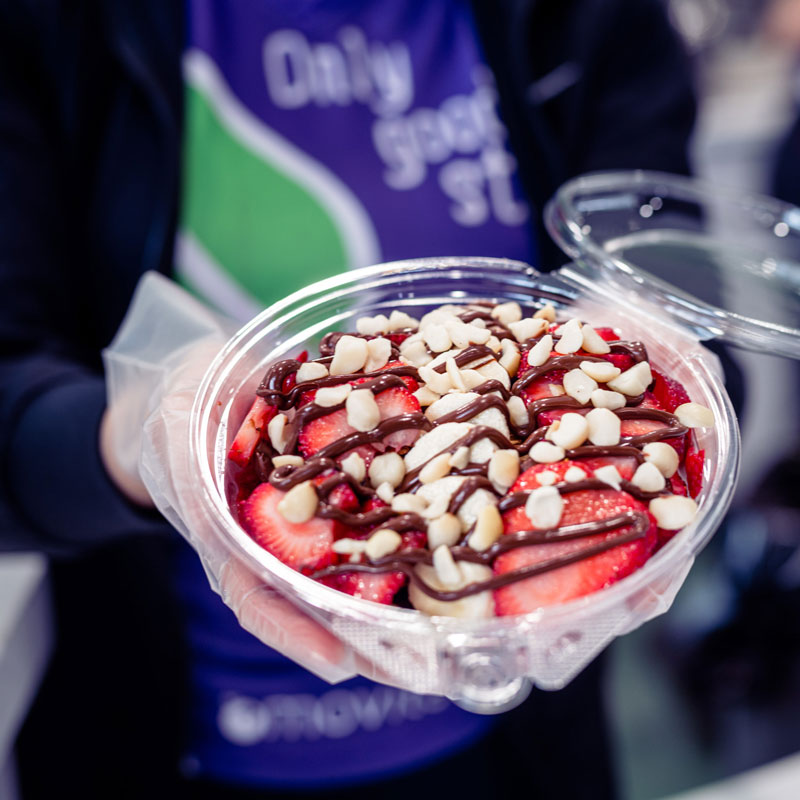 Movita Barista holding Açai bowl while wearing gloves